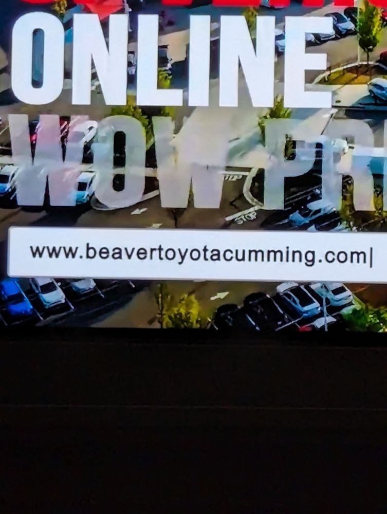 A picture of a part of a TV commercial that says www.beavertoyotacumming.com