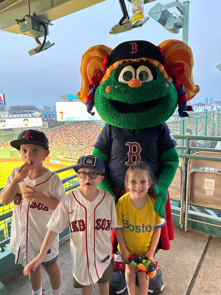 Owen poses for a photo with Wally and his two siblings at Fenway Park.
