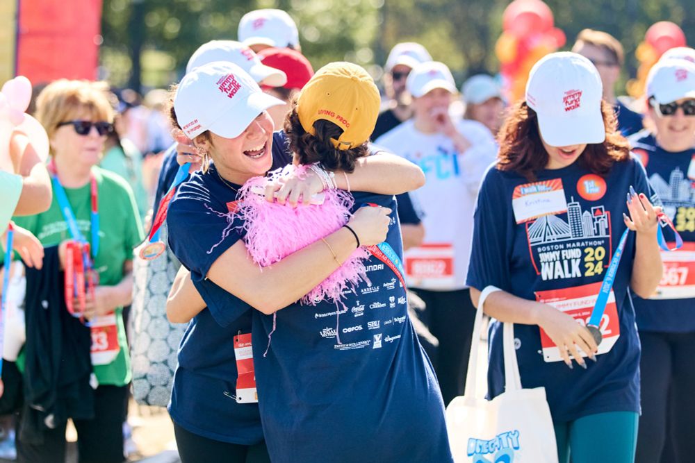Two Jimmy Fund Walk participants hug after crossing the finish line.