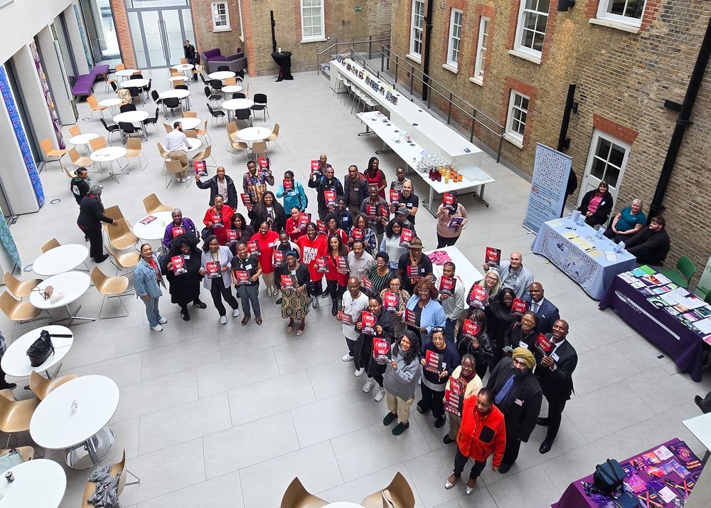 High angle shot of attendees at UNISON Black History Month event holding up placards promoting Wear Red Day 2025.