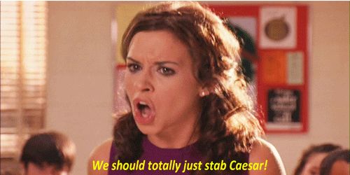 Gretchen Wieners in Mean Girls standing up in her English class. She looks very upset and is yelling. The caption reads “WE SHOULD TOTALLY JUST STAB CAESAR!”