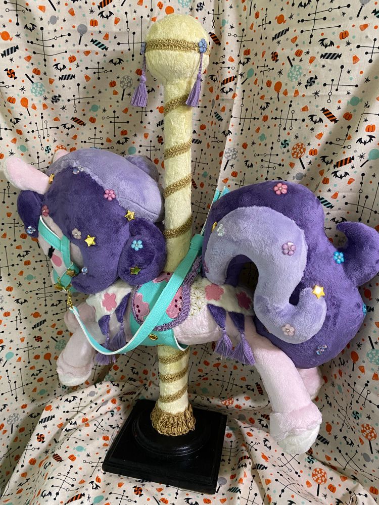 Pink and purple carousel horse plush with teal saddle and tack