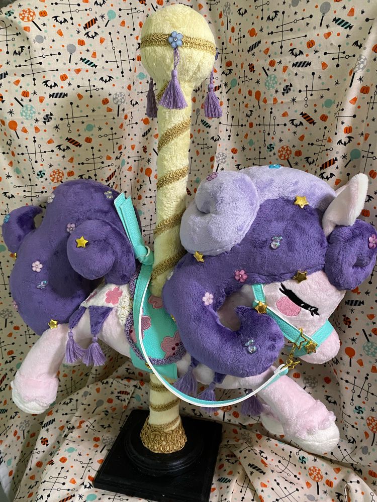 Pink and purple carousel horse plush with teal saddle and tack