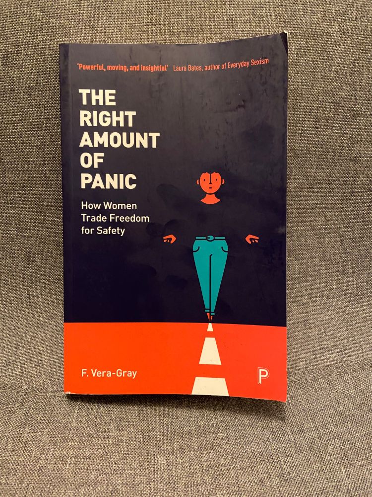 The book cover of The Right Amount of Panic by F Vera-Gray shows an illustration of a woman wearing a dark blue top and light blue trousers walking a white dotted line.