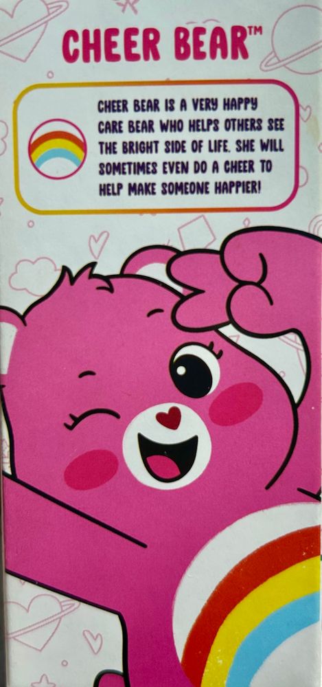 A pink Care Bears mini cheer bear with a red, yellow, and blue rainbow on its stomach and a pink heart nose “cheer bear is a very happy care bear who helps others see the bright side of life. She will sometimes even do a cheer to help make someone happier” 
