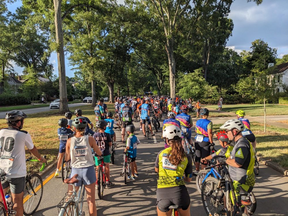 A photo of the starting lineup for 24 Hours of Booty. There are a large number of cyclists stretching up a hill.