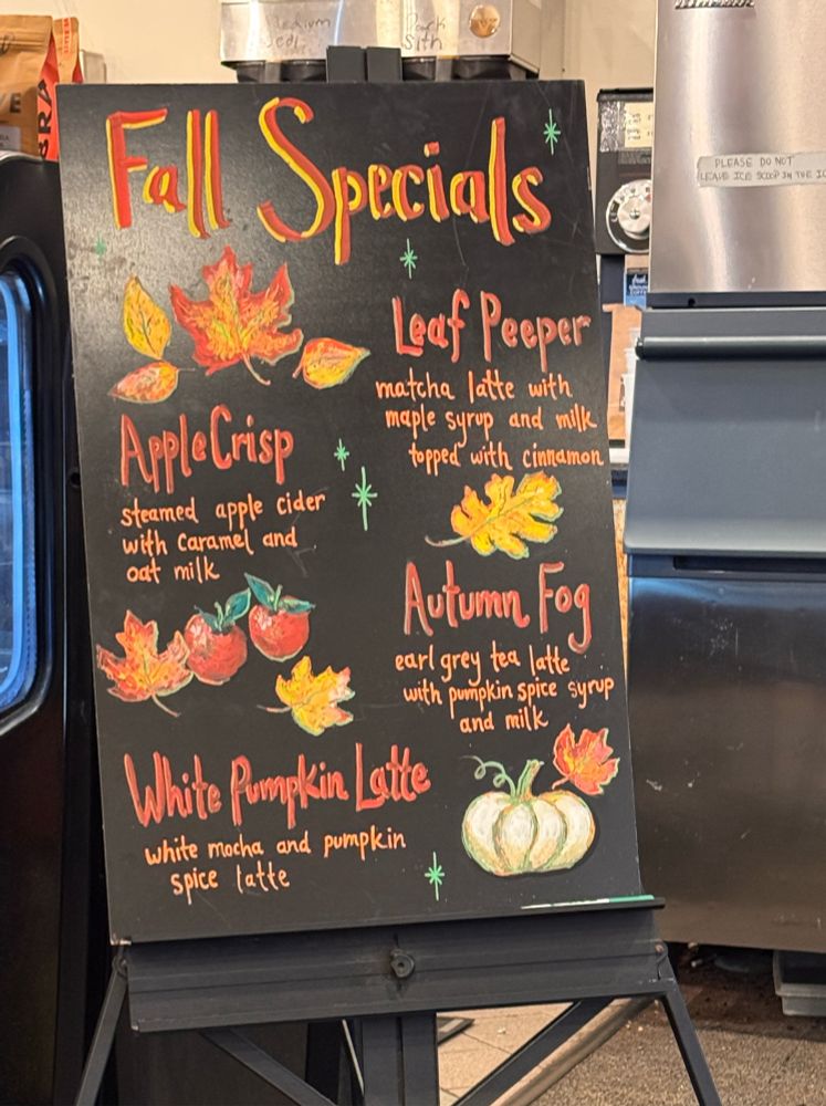 A sign at a local coffee shop that lists various fall specials, decorated with hand drawn art. There’s the “White Pumpkin Latte” and “Autumn Fog”, amongst others, including the “Leaf Peeper” 