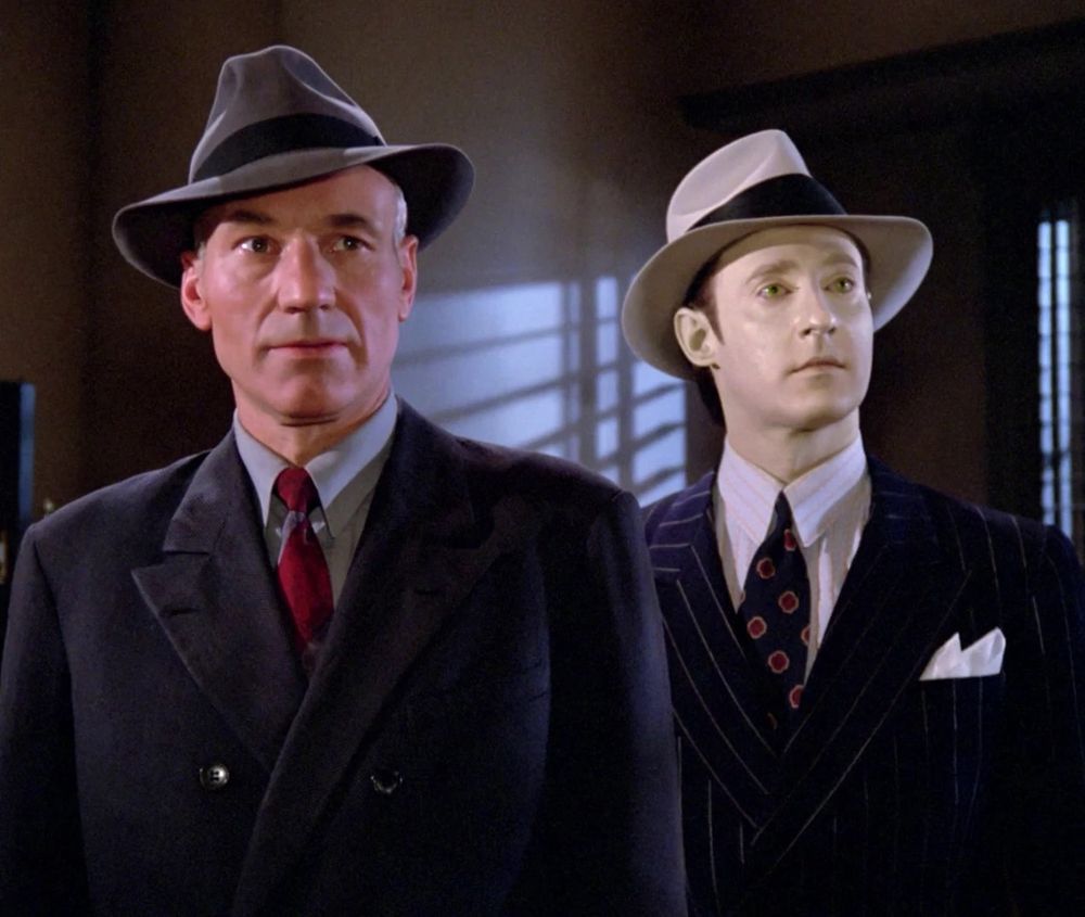 Picard and Data wearing snazzy noir-style outfits.