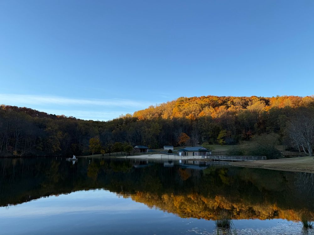 Still pond with reflection from the illuminated hill behind it
