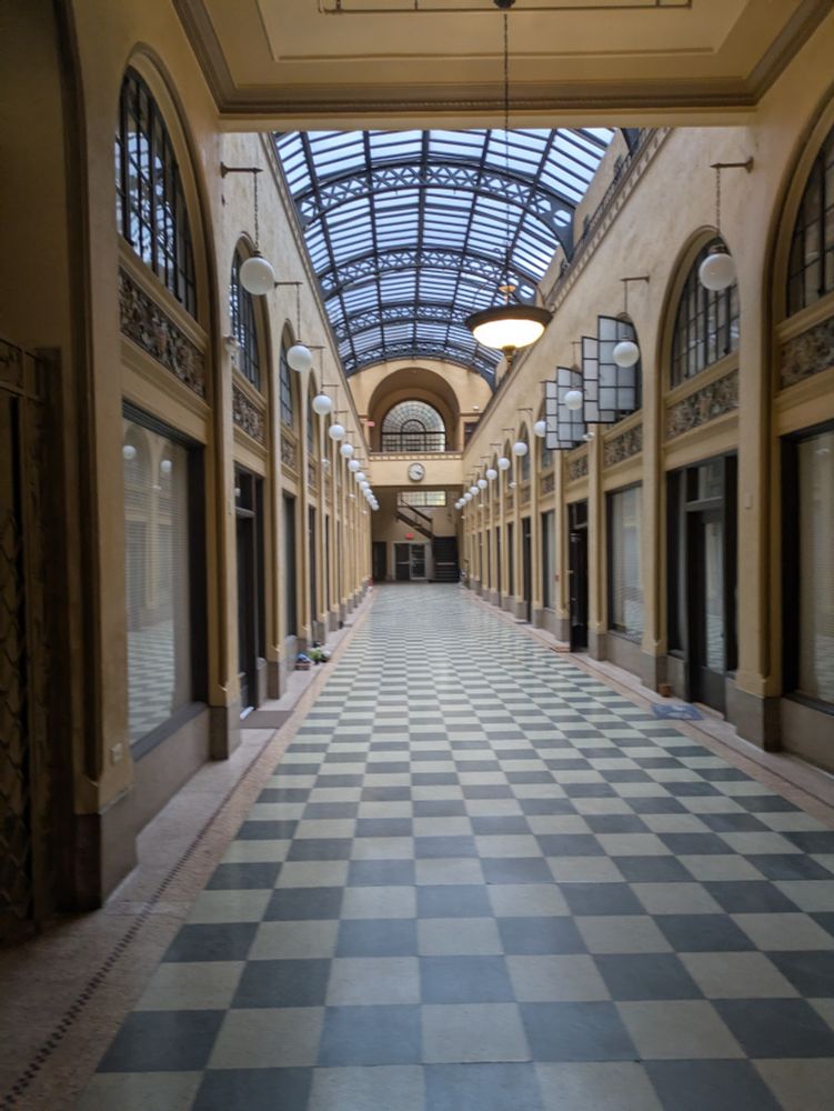 A shopping arcade that has been converted into apartments, glass ceiling, checker tiled floor, historic fixtures 