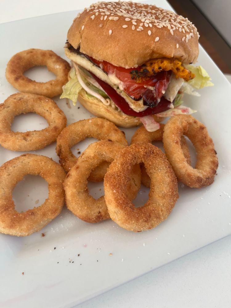 Photo of a pumpkin, capsicum and halloumi burger with onion rings 