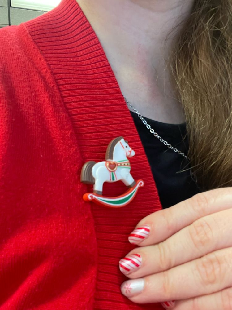 A white rocking horse with brown mane and a heart shaped saddle 