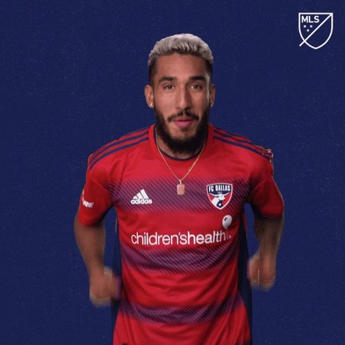 a man in a red dallas fc jersey says vamos