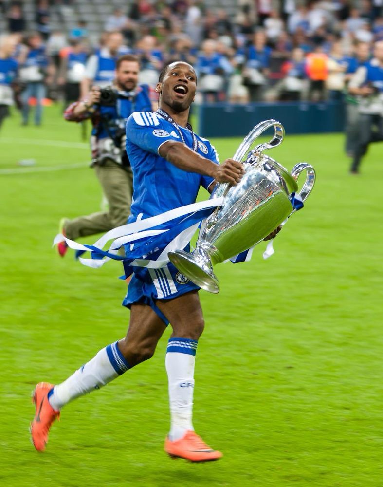 Drogba running with the Champions League Trophy