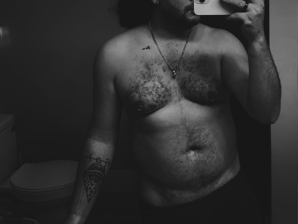 black and white photo of Ghost in the bathroom mirror shirtless 