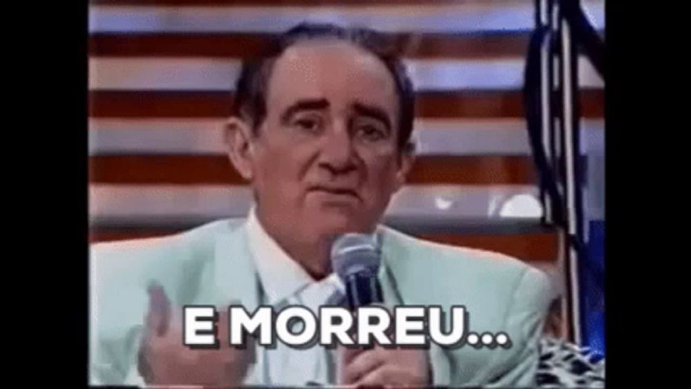 a man in a suit is talking into a microphone and saying `` e morreu '' .