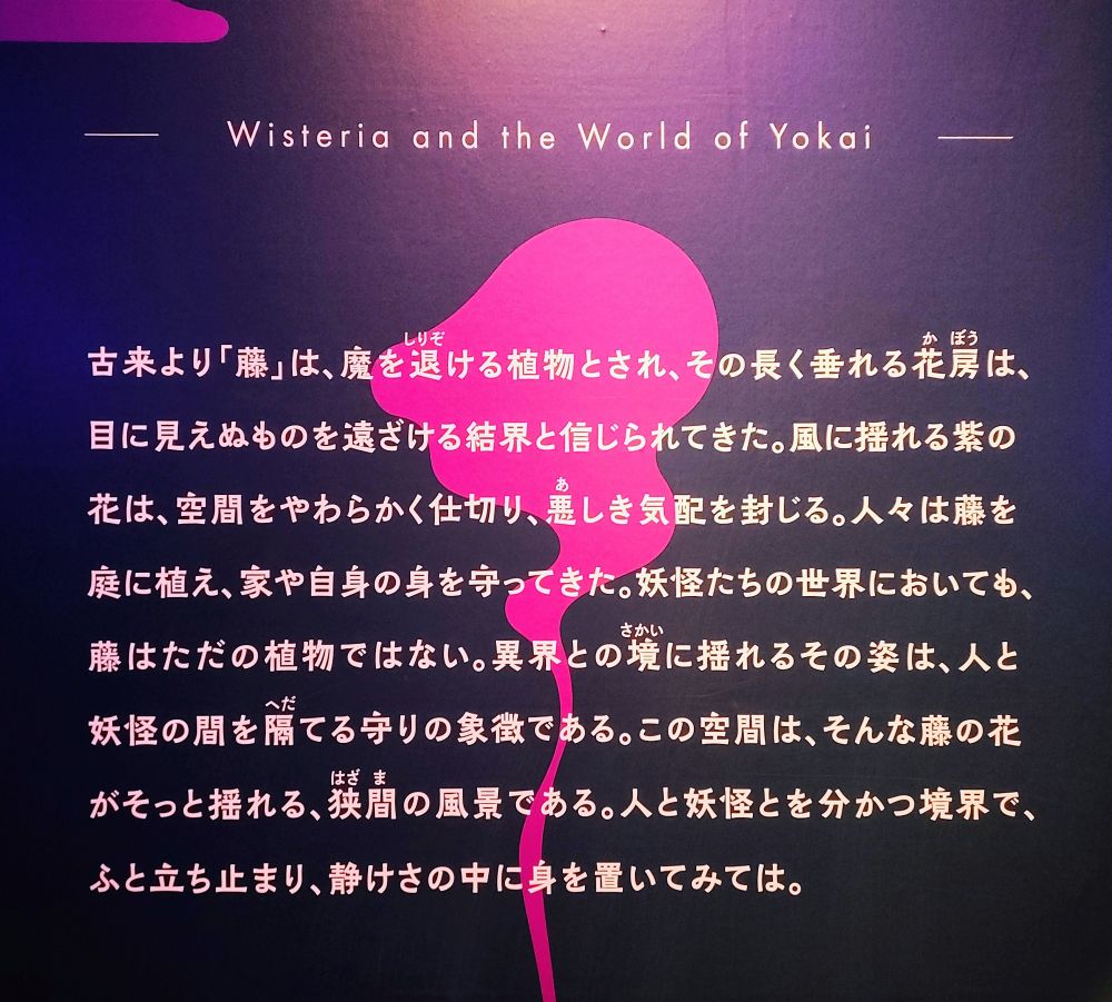 文字のパネル
そのまま書き写しています

古来より「藤」は、魔を退ける植物とされ、その長く垂れる花房は、
目に見えぬものを遠ざける結界と信じられてきた。
風に揺れる紫の花は、空間をやわらかく仕切り、悪しき気配を封じる。
人々は藤を庭に植え、家や自身の身を守ってきた。
妖怪たちの世界においても、藤はただの植物ではない。
異界との境に揺れるその姿は、人と妖怪の間を隔てる守りの象徴である。
この空間は、そんな藤の花がそっと揺れる、狭間の風景である。
人と妖怪とを分かつ境界で、ふと立ち止まり、静けさの中に身を置いてみては。