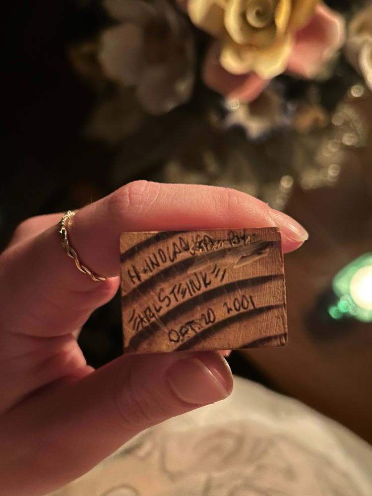 A signature on the wooden carving stating “hand carved by earl steinke oct. 20 2001” 