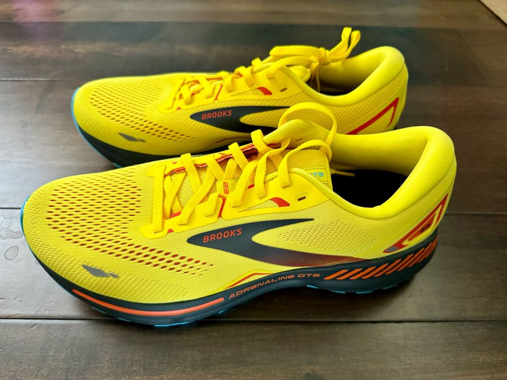 A garish pair of yellow, black, and orange Brooks Adrenaline GTS running shoes. 