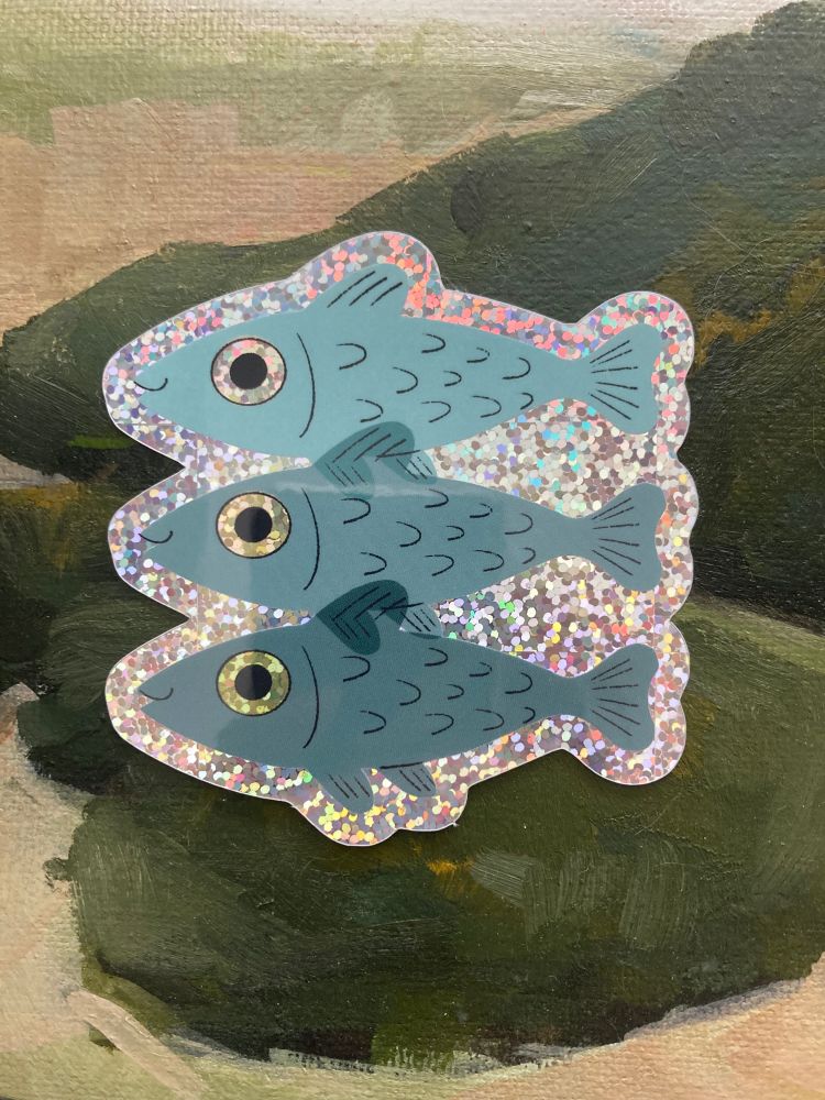 glittery sticker of three turquoise fish stacked on top of each other