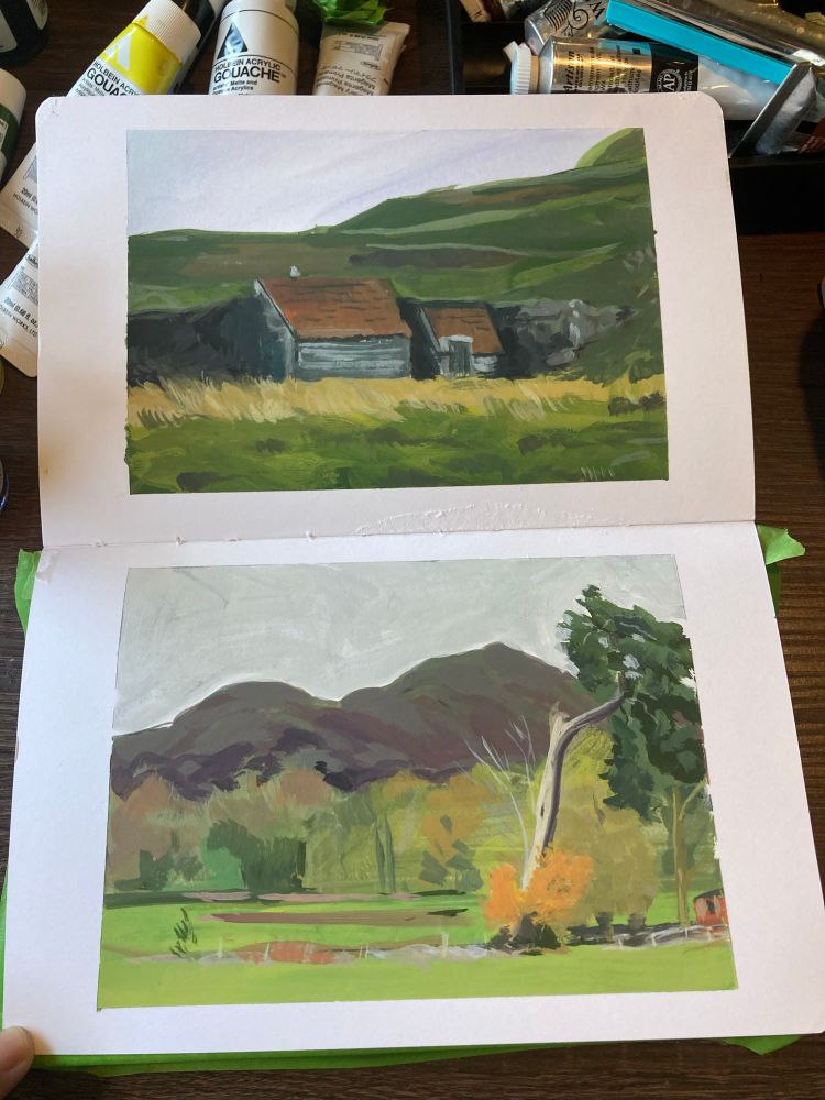 Sketchbook with two gouache paintings. A hut tucked into a hillside and a twisty cypress on a green field with mountains in the distance. 