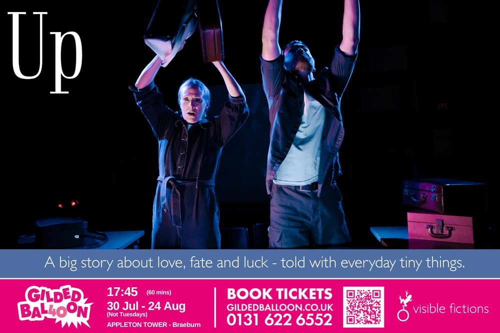 Two persons standing on a dark stage with dramatic lighting. Their arms are reaching up. One looks scared.