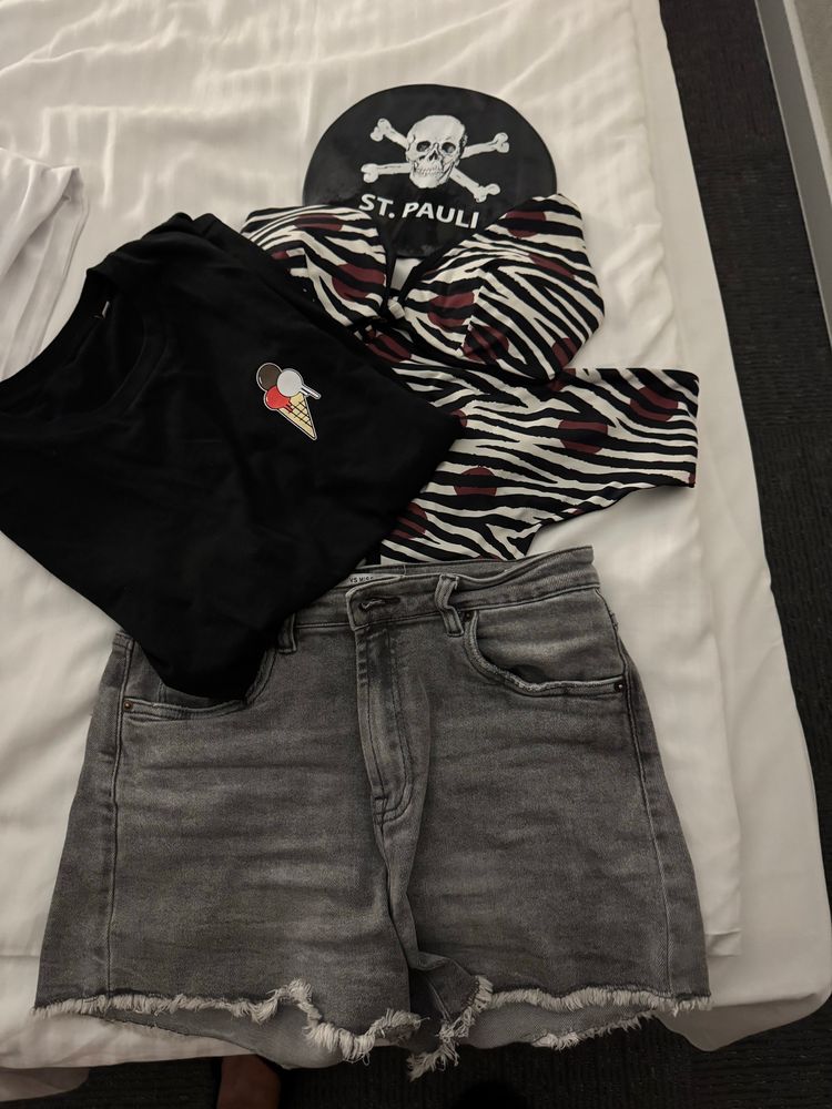 Susan Pokal Outfit: a black bath cap with the FC St. Pauli Logo, jeans shorts, black shirt with an ice cream cone logo which is a fan shirt and a brown/black and white stripped bikini. 