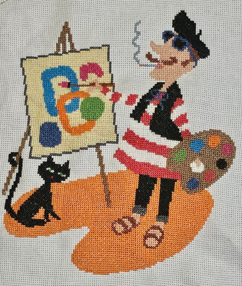 Cross stitch of a painter and a cat