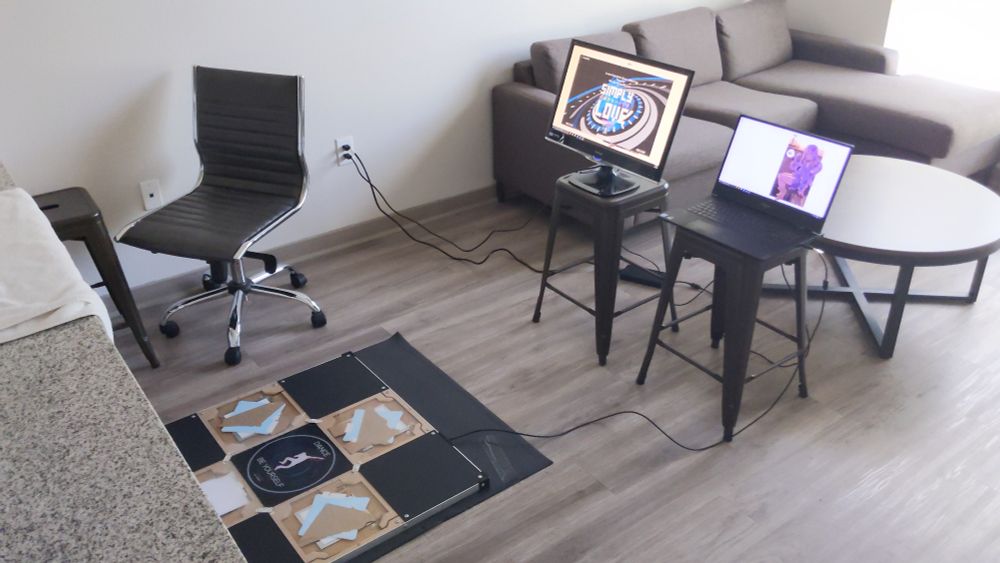 image of a scuffed ITG setup featuring a monitor + laptop placed on stools and a kitchen counter being used as a bar