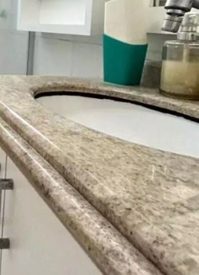 Fotografia antiga da pia, como era no anúncio. A pia tinha granito claro, com a cuba da pia branca e uma mancha preta no vão entre o granito e a pia; a crosta preta que achávamos que era alguma ferrugem da pia ou silicone preto. 