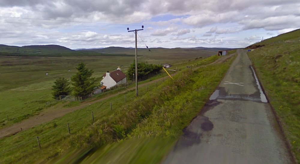 A single track raod and a white house set back from the road its the middle of fucking no where