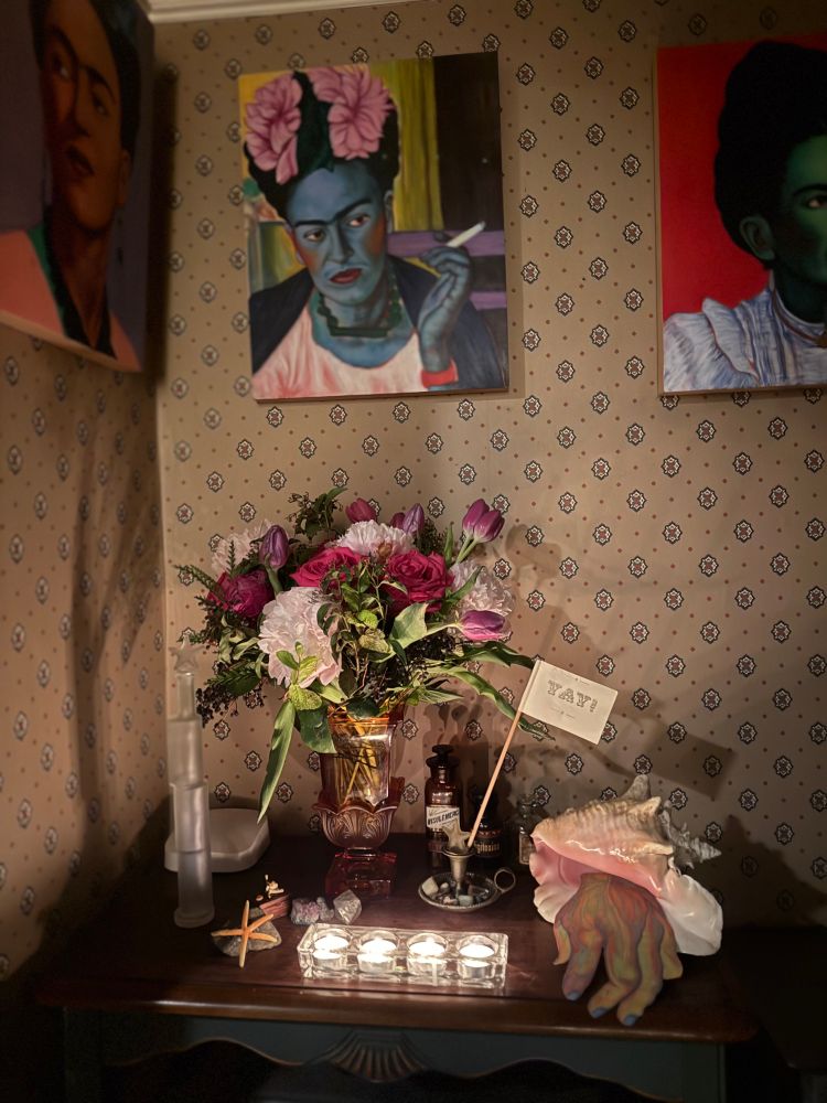 Candlelit bouquet of colorful flowers with my Frida Kahlo painting—she is smoking with a pink flower in her hair