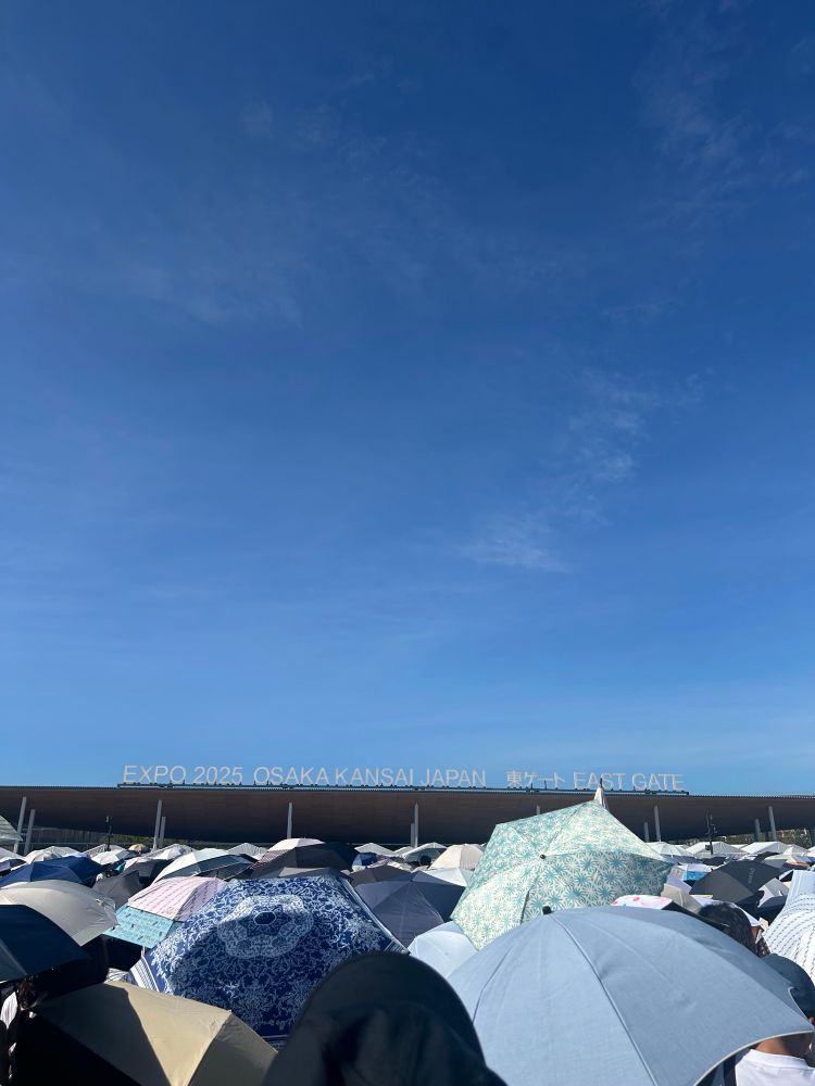青空の下　満開の日傘が並ぶ　万博東ゲートの写真