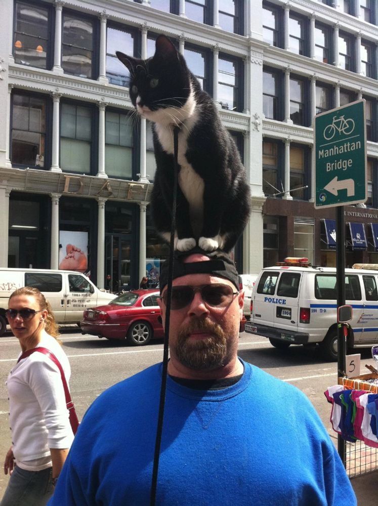 A local NYC street figure, Charlie Perito. He's famous for walking around with his black and white cat sitting on top of his head. 