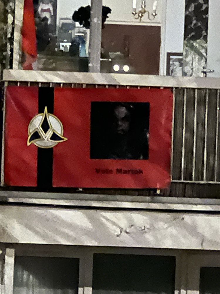A banner hanging from a balcony calling on all of us to ‘vote for Martok’, a Klingon general from Star Trek