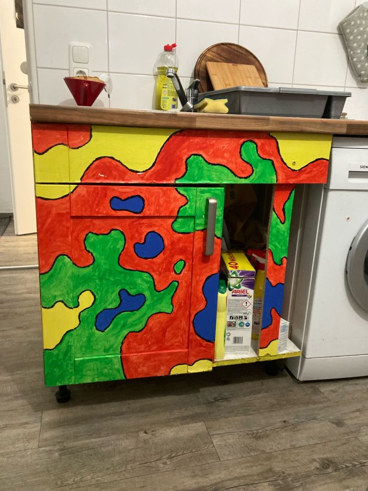 ein teil der küchenzeile ist bunt angemalt: psychedelisch anmutendes muster in rot, grün, blau und gelb