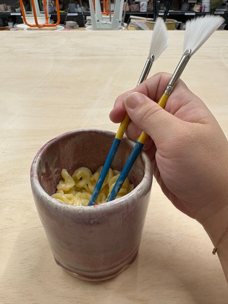 eating pasta out of my own cup using brushes as chopsticks 