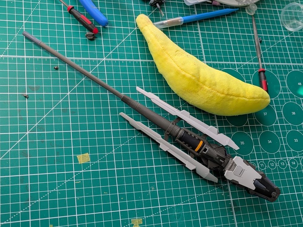 A large plastic gun, it is deployed and ready for action, they are kind of taking the piss with how large this is. There is a banana (and probably slightly more helpful 10mm) grid for scale