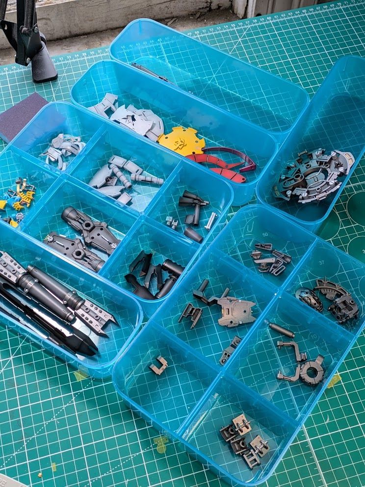 A collections of gunpla pieces in a clear blue part separator.