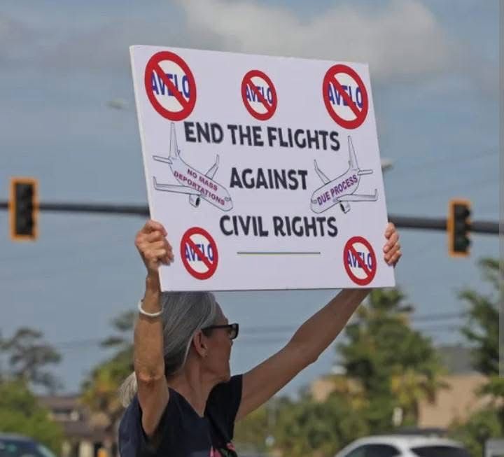 Woman holds sign with slogan “End the flights against civil rights” against Avelo airlines 