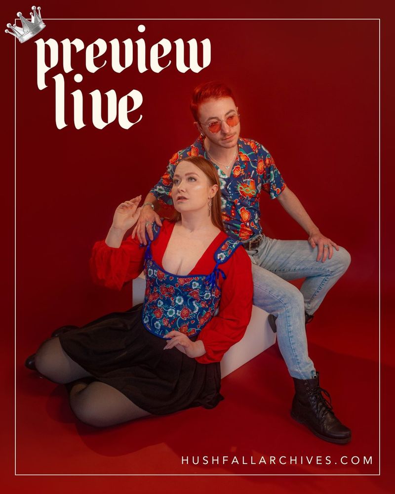 A still image of @parkerbliss and @elegantfeatherduster modeling our Saints & Sonnets collection in matching blue-and-red floral outfits. Product details for all items in our two debut collections are available on our website! Text reads: Preview live, hushfallarchives.com