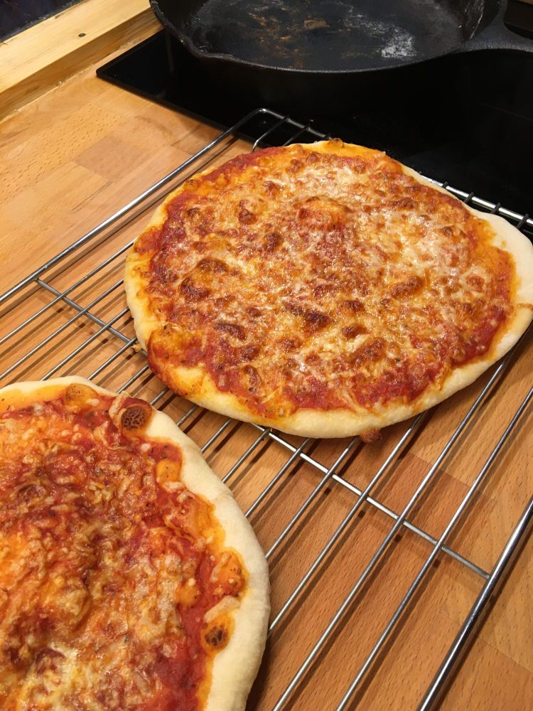 Zwei Käsepizzen auf Gitter zum Abkühlen