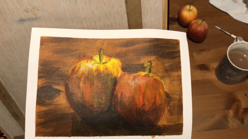 A painting of two apples on a wooden table