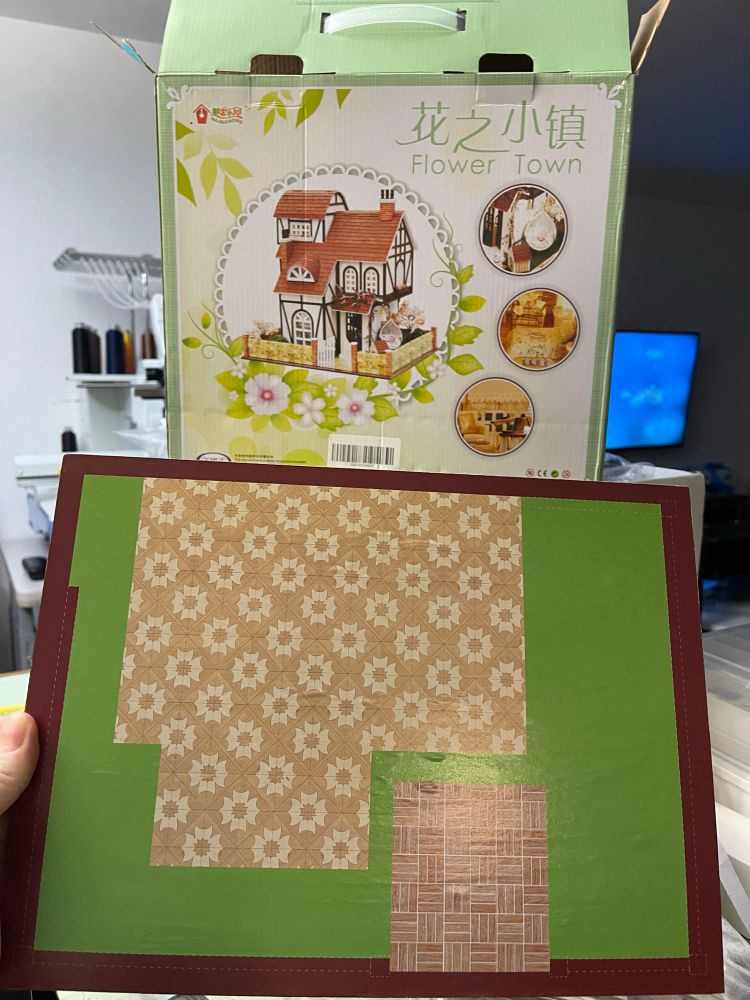 Box for dollhouse kit and the floor of the dollhouse held up