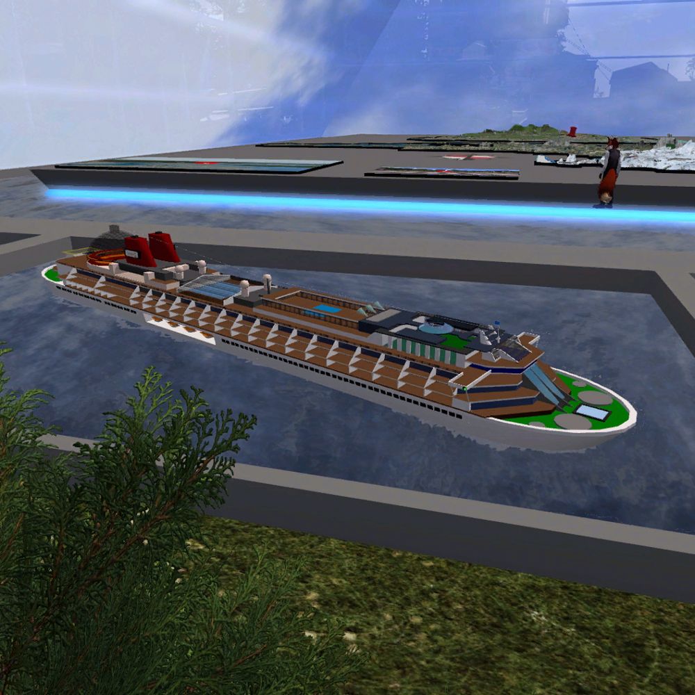 A snapshot from the virtual world of Second Life, showing Snowlord's prim-based miniature of the SS Galaxy cruise ship. The ship is "anchored" in a small water feature at the front of my SL22B exhibit parcel, with the snapshot also showing my fox avatar and the large topographic models in the background.