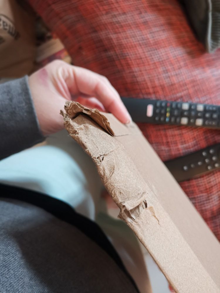 Coin d'une enveloppe cartonnée ayant pris l'eau et étant bien abîmé. 