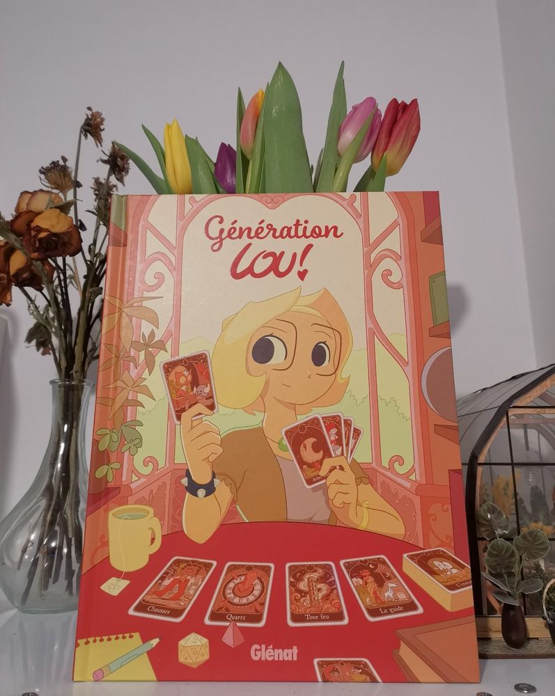 BD Generation Lou toujours debant le bouquet de tulipes. On y voit Lou adulte avec des cartes de tarot. 