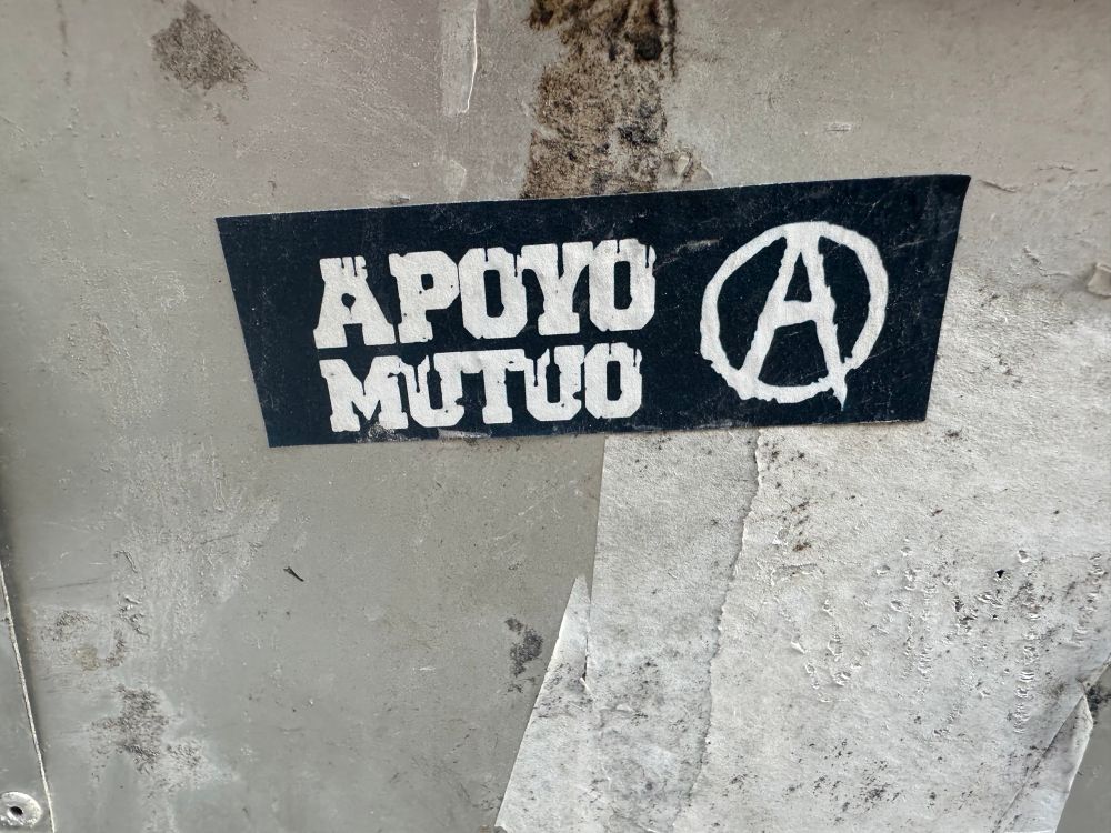 Zwarte sticker met de witte Spaanse tekst ‘apoyo mutuo’