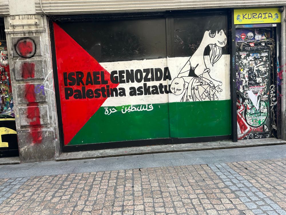 Muurschildering in Bilbao met een Palestijnse vlag met de Baskische tekst Isreal genozida, Palestine askatu.