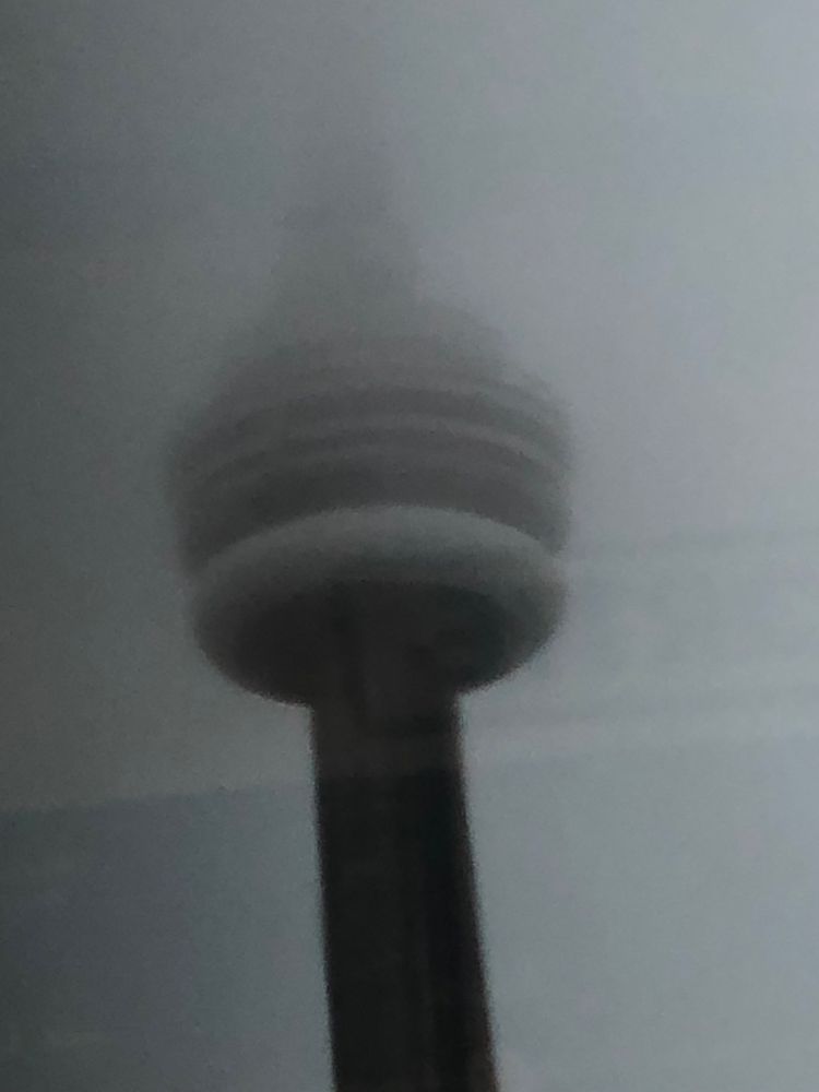 Cn tower it’s top in clouds, reflections on glass 